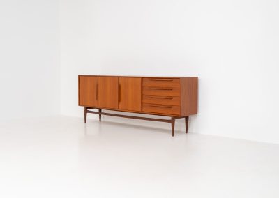 “RT200” sideboard by Heinrich Riestenpatt (Germany, 1960s). A very elegant sideboard by German designer Heinrich Riestenpatt, executed in warm teak. The clean, architectural form is complemented by stunning organic handles and beautifully balanced proportions. A distinctive feature of this piece is the set of sculpted, slightly stepped drawers, offering both visual rhythm and practical storage. Three doors reveal generous interior space, making the sideboard as functional as it is refined. A timeless example of German modern design, presented in excellent vintage condition.