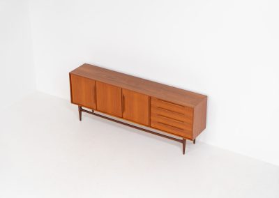 “RT200” sideboard by Heinrich Riestenpatt (Germany, 1960s). A very elegant sideboard by German designer Heinrich Riestenpatt, executed in warm teak. The clean, architectural form is complemented by stunning organic handles and beautifully balanced proportions. A distinctive feature of this piece is the set of sculpted, slightly stepped drawers, offering both visual rhythm and practical storage. Three doors reveal generous interior space, making the sideboard as functional as it is refined. A timeless example of German modern design, presented in excellent vintage condition.