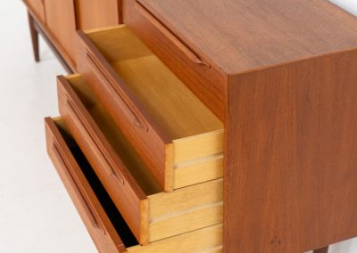 “RT200” sideboard by Heinrich Riestenpatt (Germany, 1960s). A very elegant sideboard by German designer Heinrich Riestenpatt, executed in warm teak. The clean, architectural form is complemented by stunning organic handles and beautifully balanced proportions. A distinctive feature of this piece is the set of sculpted, slightly stepped drawers, offering both visual rhythm and practical storage. Three doors reveal generous interior space, making the sideboard as functional as it is refined. A timeless example of German modern design, presented in excellent vintage condition.