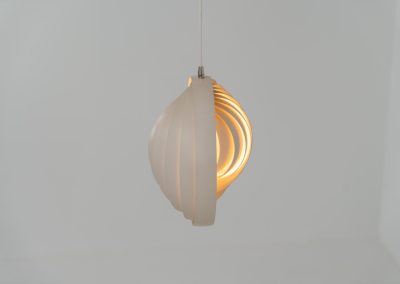A wonderful example of an early “Moon” pendant light by Verner Panton for Louis Poulsen (Denmark, 1960s). An early model of the iconic Space Age "moon lamp," also known as the Visor pendant, designed by Verner Panton in the 1960s and produced by Louis Poulsen, Denmark. This sculptural piece features ten white, rotatable rings made of enameled metal, arranged around a central light source. The adjustable blades allow for subtle variation in light diffusion, creating a warm, atmospheric glow while maintaining its striking geometric presence. A true Danish Op-Art design classic, the lamp combines functionality with a bold visual identity that remains timeless. The lamp is in very good vintage condition with some minor scuffs in the paint.