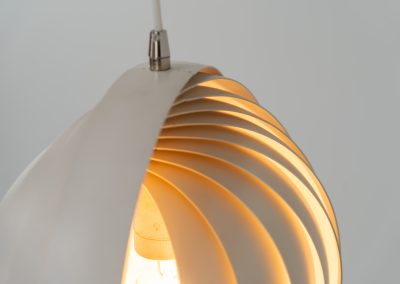 A wonderful example of an early “Moon” pendant light by Verner Panton for Louis Poulsen (Denmark, 1960s). An early model of the iconic Space Age "moon lamp," also known as the Visor pendant, designed by Verner Panton in the 1960s and produced by Louis Poulsen, Denmark. This sculptural piece features ten white, rotatable rings made of enameled metal, arranged around a central light source. The adjustable blades allow for subtle variation in light diffusion, creating a warm, atmospheric glow while maintaining its striking geometric presence. A true Danish Op-Art design classic, the lamp combines functionality with a bold visual identity that remains timeless. The lamp is in very good vintage condition with some minor scuffs in the paint.