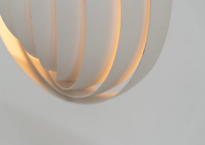 A wonderful example of an early “Moon” pendant light by Verner Panton for Louis Poulsen (Denmark, 1960s). An early model of the iconic Space Age "moon lamp," also known as the Visor pendant, designed by Verner Panton in the 1960s and produced by Louis Poulsen, Denmark. This sculptural piece features ten white, rotatable rings made of enameled metal, arranged around a central light source. The adjustable blades allow for subtle variation in light diffusion, creating a warm, atmospheric glow while maintaining its striking geometric presence. A true Danish Op-Art design classic, the lamp combines functionality with a bold visual identity that remains timeless. The lamp is in very good vintage condition with some minor scuffs in the paint.