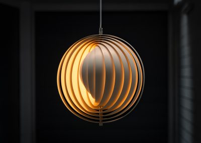 A wonderful example of an early “Moon” pendant light by Verner Panton for Louis Poulsen (Denmark, 1960s). An early model of the iconic Space Age "moon lamp," also known as the Visor pendant, designed by Verner Panton in the 1960s and produced by Louis Poulsen, Denmark. This sculptural piece features ten white, rotatable rings made of enameled metal, arranged around a central light source. The adjustable blades allow for subtle variation in light diffusion, creating a warm, atmospheric glow while maintaining its striking geometric presence. A true Danish Op-Art design classic, the lamp combines functionality with a bold visual identity that remains timeless. The lamp is in very good vintage condition with some minor scuffs in the paint.