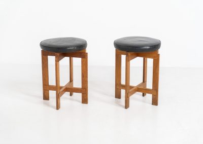 Very rare set of stools by Uno & Östen Kristiansson for Luxus Vittsjö (Sweden, 1950s). A highly collectible find, designed by the renowned brothers Uno & Östen Kristiansson and a true masterclass in Scandinavian architectural furniture. They consist of a solid oak cross-shaped base and a round leather seat, two in black and one in red. They are in used vintage condition with a nice patina on the seats and visible using traces on the wood. The two black stools can be sold separately upon request.