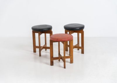Very rare set of stools by Uno & Östen Kristiansson for Luxus Vittsjö (Sweden, 1950s). A highly collectible find, designed by the renowned brothers Uno & Östen Kristiansson and a true masterclass in Scandinavian architectural furniture. They consist of a solid oak cross-shaped base and a round leather seat, two in black and one in red. They are in used vintage condition with a nice patina on the seats and visible using traces on the wood. The two black stools can be sold separately upon request.