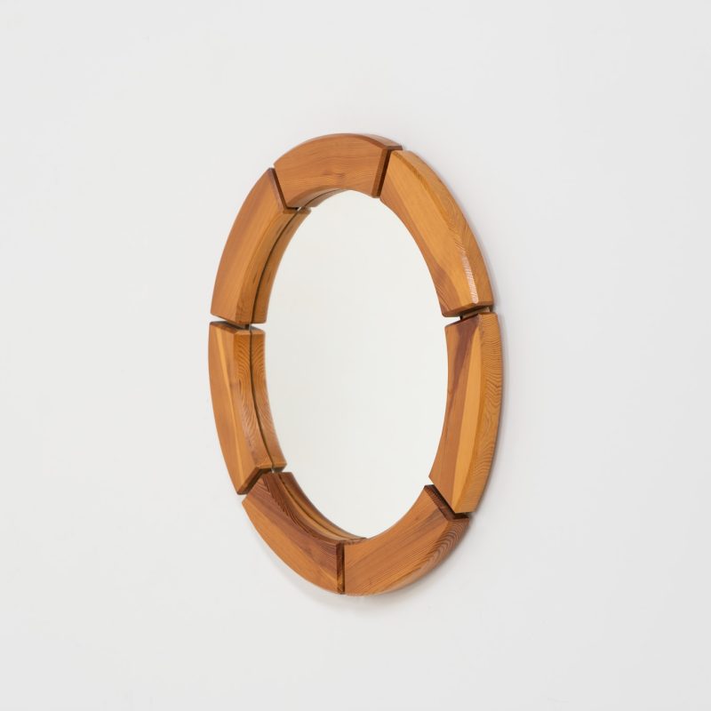 Sculptural wall-mirror in solid pine (Sweden, 1970s). This stunning Swedish mirror is crafted from solid pine, showcasing a bold and sculptural appearance. The mirror remains in excellent condition.