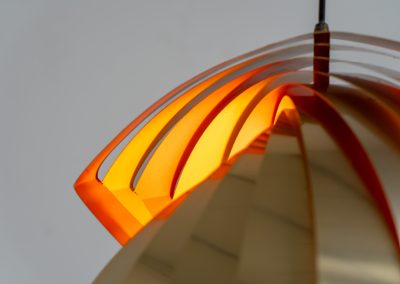 “Konkylie” pendant light by Louis Weisdorf for Lyfa (Denmark, 1960s). A strong, sculptural design with a clear architectural feel, typical of Weisdorf’s work. The layered brass shades unfold like a shell, revealing a striking red and orange interior that adds depth and warmth. When lit, the light is softly diffused, creating a rich, atmospheric glow with subtle color reflection. The interplay between the polished brass exterior and the warm-toned interior gives the piece a dynamic character. A well-balanced design that works just as well as a statement piece above a dining table as it does in a more minimal setting. A solid example of Danish mid-century lighting, where form and function meet effortlessly.