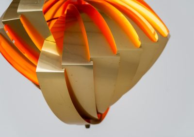 “Konkylie” pendant light by Louis Weisdorf for Lyfa (Denmark, 1960s). A strong, sculptural design with a clear architectural feel, typical of Weisdorf’s work. The layered brass shades unfold like a shell, revealing a striking red and orange interior that adds depth and warmth. When lit, the light is softly diffused, creating a rich, atmospheric glow with subtle color reflection. The interplay between the polished brass exterior and the warm-toned interior gives the piece a dynamic character. A well-balanced design that works just as well as a statement piece above a dining table as it does in a more minimal setting. A solid example of Danish mid-century lighting, where form and function meet effortlessly.
