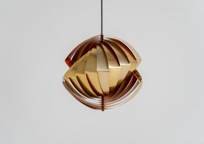 “Konkylie” pendant light by Louis Weisdorf for Lyfa (Denmark, 1960s). A strong, sculptural design with a clear architectural feel, typical of Weisdorf’s work. The layered brass shades unfold like a shell, revealing a striking red and orange interior that adds depth and warmth. When lit, the light is softly diffused, creating a rich, atmospheric glow with subtle color reflection. The interplay between the polished brass exterior and the warm-toned interior gives the piece a dynamic character. A well-balanced design that works just as well as a statement piece above a dining table as it does in a more minimal setting. A solid example of Danish mid-century lighting, where form and function meet effortlessly.