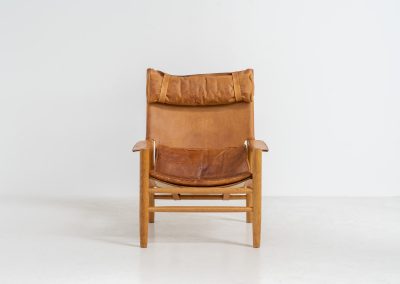 “Dormi” Lounge Chair by Kenneth Bergenblad for DUX (Sweden, 1970s). Rare “Dormi” lounge chair with a solid oak frame and thick leather sling seat, designed by Kenneth Bergenblad for DUX. A beautiful example of relaxed Scandinavian modern design with a strong, understated presence. The leather shows pronounced patina and wear, giving it a very lived-in, raw character. Important to note: this condition is quite present and not for everyone. Structurally sound and comfortable, with a warm-toned frame that pairs perfectly with the worn leather.