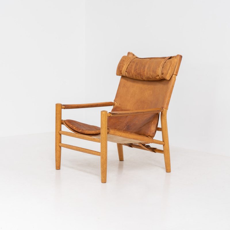 “Dormi” Lounge Chair by Kenneth Bergenblad for DUX (Sweden, 1970s). Rare “Dormi” lounge chair with a solid oak frame and thick leather sling seat, designed by Kenneth Bergenblad for DUX. A beautiful example of relaxed Scandinavian modern design with a strong, understated presence. The leather shows pronounced patina and wear, giving it a very lived-in, raw character. Important to note: this condition is quite present and not for everyone. Structurally sound and comfortable, with a warm-toned frame that pairs perfectly with the worn leather.