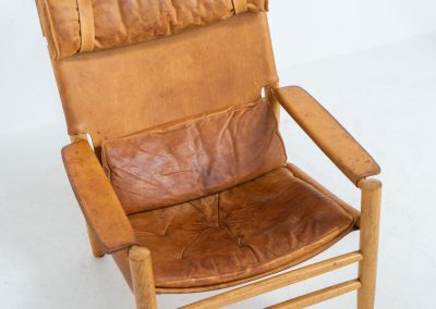 “Dormi” Lounge Chair by Kenneth Bergenblad for DUX (Sweden, 1970s). Rare “Dormi” lounge chair with a solid oak frame and thick leather sling seat, designed by Kenneth Bergenblad for DUX. A beautiful example of relaxed Scandinavian modern design with a strong, understated presence. The leather shows pronounced patina and wear, giving it a very lived-in, raw character. Important to note: this condition is quite present and not for everyone. Structurally sound and comfortable, with a warm-toned frame that pairs perfectly with the worn leather.