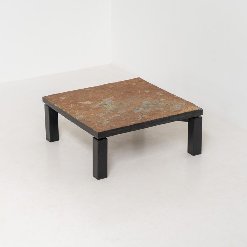 Brutalist Coffee Table in Norwegian Slate stone, 1970s A very powerful Brutalist coffee table from the 1970s, defined by its strong architectural presence and sculptural simplicity. The substantial tabletop is crafted from Norwegian slate, showcasing a rich and varied surface with natural tonal shifts that create depth and visual texture. The solid stone top is supported by a black lacquered metal base, offering a bold contrast while reinforcing the table’s grounded and monolithic character. The table remains in very good condition, with light, age-appropriate wear such as minor scratches to the frame.