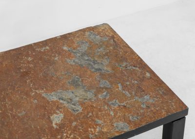 Brutalist Coffee Table in Norwegian Slate stone, 1970s A very powerful Brutalist coffee table from the 1970s, defined by its strong architectural presence and sculptural simplicity. The substantial tabletop is crafted from Norwegian slate, showcasing a rich and varied surface with natural tonal shifts that create depth and visual texture. The solid stone top is supported by a black lacquered metal base, offering a bold contrast while reinforcing the table’s grounded and monolithic character. The table remains in very good condition, with light, age-appropriate wear such as minor scratches to the frame.
