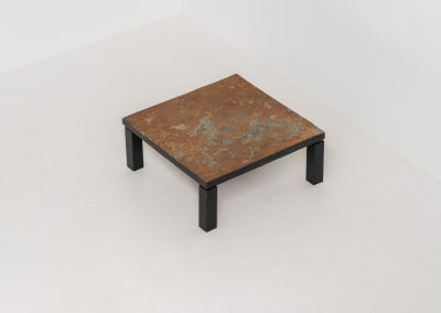 Brutalist Coffee Table in Norwegian Slate stone, 1970s A very powerful Brutalist coffee table from the 1970s, defined by its strong architectural presence and sculptural simplicity. The substantial tabletop is crafted from Norwegian slate, showcasing a rich and varied surface with natural tonal shifts that create depth and visual texture. The solid stone top is supported by a black lacquered metal base, offering a bold contrast while reinforcing the table’s grounded and monolithic character. The table remains in very good condition, with light, age-appropriate wear such as minor scratches to the frame.