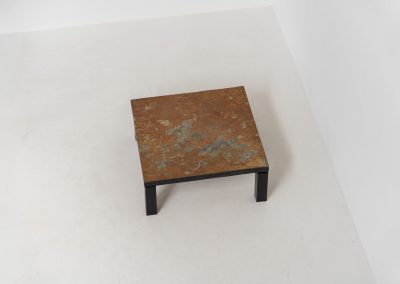 Brutalist Coffee Table in Norwegian Slate stone, 1970s A very powerful Brutalist coffee table from the 1970s, defined by its strong architectural presence and sculptural simplicity. The substantial tabletop is crafted from Norwegian slate, showcasing a rich and varied surface with natural tonal shifts that create depth and visual texture. The solid stone top is supported by a black lacquered metal base, offering a bold contrast while reinforcing the table’s grounded and monolithic character. The table remains in very good condition, with light, age-appropriate wear such as minor scratches to the frame.