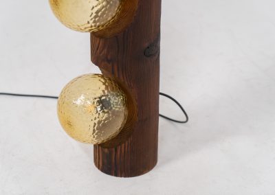 Sculptural floor lamp by Temde Leuchten (Switzerland, 1970s). This exceptional piece combines an organic form with a subtle brutalist character. It is crafted from solid burnt oak and features three round glass light sources that create a warm, atmospheric glow. Versatile in use, the lamp can function as a mid-height floor lamp, a table lamp, or even a wall-mounted piece thanks to its integrated rear mountings. The lamp remains in very good condition, with the wood showing a beautifully aged patina that enhances its character.