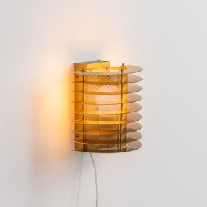 Wall light by Borens (Sweden, 1980s). A refined example of Scandinavian modernism, this wall lamp features layered metal shades surrounding a perforated inner cylinder, creating a warm, diffused glow. The structured, almost architectural design adds depth while maintaining a clean and balanced aesthetic. In very good vintage condition with a mild patina to the metal. Marked by maker.