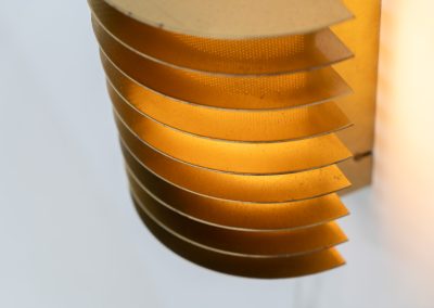 Wall light by Borens (Sweden, 1980s). A refined example of Scandinavian modernism, this wall lamp features layered metal shades surrounding a perforated inner cylinder, creating a warm, diffused glow. The structured, almost architectural design adds depth while maintaining a clean and balanced aesthetic. In very good vintage condition with a mild patina to the metal. Marked by maker.