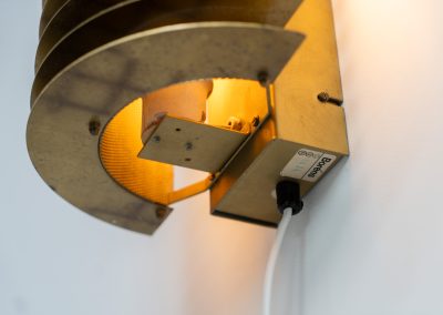Wall light by Borens (Sweden, 1980s). A refined example of Scandinavian modernism, this wall lamp features layered metal shades surrounding a perforated inner cylinder, creating a warm, diffused glow. The structured, almost architectural design adds depth while maintaining a clean and balanced aesthetic. In very good vintage condition with a mild patina to the metal. Marked by maker.