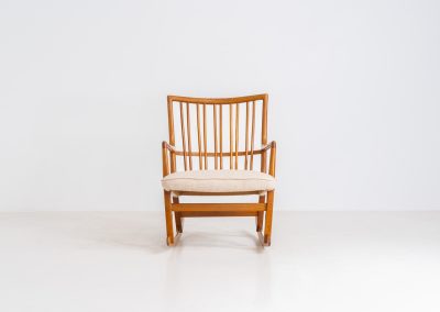 A rare “ML33” rocking chair by Hans J. Wegner for A. Mikael Laursen (Denmark, 1950s). Pure Danish craftsmanship from the 1950s, featuring a highly sculptural silhouette crafted from solid oak. A true masterpiece of mid-century design. The chair has been reupholstered in a beautifully textured of-white fabric and contains new straps.