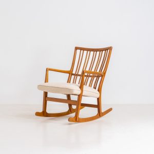 A rare “ML33” rocking chair by Hans J. Wegner for A. Mikael Laursen (Denmark, 1950s). Pure Danish craftsmanship from the 1950s, featuring a highly sculptural silhouette crafted from solid oak. A true masterpiece of mid-century design. The chair has been reupholstered in a beautifully textured of-white fabric and contains new straps.