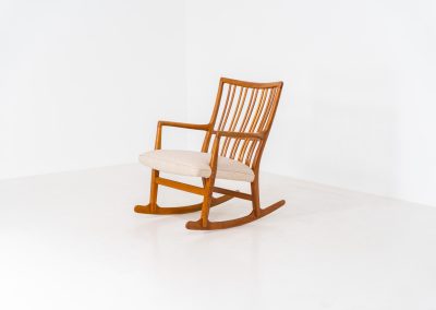 A rare “ML33” rocking chair by Hans J. Wegner for A. Mikael Laursen (Denmark, 1950s). Pure Danish craftsmanship from the 1950s, featuring a highly sculptural silhouette crafted from solid oak. A true masterpiece of mid-century design. The chair has been reupholstered in a beautifully textured of-white fabric and contains new straps.