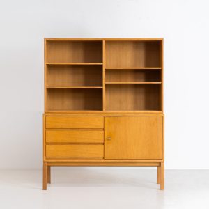 Bookcase by Marianne Grabinski for Ikea (Sweden, 1960s). This two-piece bookcase was designed by Marianne Grabinski for IKEA, back when the company was still exclusively based in Sweden. It is crafted from oak and offers generous storage space, featuring four adjustable shelves, three drawers, and a cabinet with a functional lock. The bookcase is in very good condition, showing only minor signs of age and use.