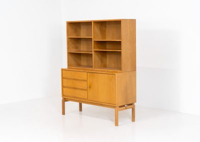Bookcase by Marianne Grabinski for Ikea (Sweden, 1960s). This two-piece bookcase was designed by Marianne Grabinski for IKEA, back when the company was still exclusively based in Sweden. It is crafted from oak and offers generous storage space, featuring four adjustable shelves, three drawers, and a cabinet with a functional lock. The bookcase is in very good condition, showing only minor signs of age and use.