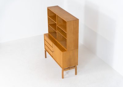 Bookcase by Marianne Grabinski for Ikea (Sweden, 1960s). This two-piece bookcase was designed by Marianne Grabinski for IKEA, back when the company was still exclusively based in Sweden. It is crafted from oak and offers generous storage space, featuring four adjustable shelves, three drawers, and a cabinet with a functional lock. The bookcase is in very good condition, showing only minor signs of age and use.