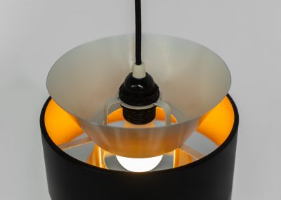 Stunning pendant light by Carl Thore for Granhaga (Sweden, 1960s). A sleek design featuring two aluminium shades and a black halo which is lacquered in yellow on the inside. The yellow interior creates a beautiful defused and moody light dispersion. The lamp remains in very good condition.
