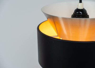 Stunning pendant light by Carl Thore for Granhaga (Sweden, 1960s). A sleek design featuring two aluminium shades and a black halo which is lacquered in yellow on the inside. The yellow interior creates a beautiful defused and moody light dispersion. The lamp remains in very good condition.