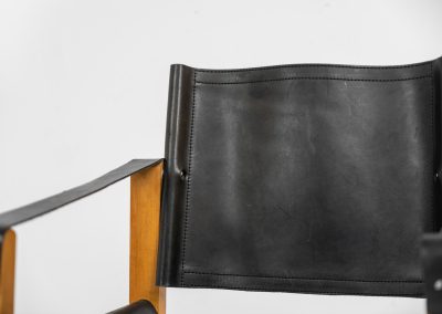 Oak & leather safari chair (Denmark, 1980s) A striking armchair from the 1980s, crafted from solid oak and fitted with a black leather seat and backrest. The design features a sturdy, architectural frame with visible joinery and cross-bracing, giving it a strong yet refined presence. It is easily foldable, reducing its footprint by roughly half when stored. The chair is in good condition, showing light signs of use and a beautiful natural patina on the leather.