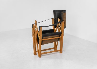 Oak & leather safari chair (Denmark, 1980s) A striking armchair from the 1980s, crafted from solid oak and fitted with a black leather seat and backrest. The design features a sturdy, architectural frame with visible joinery and cross-bracing, giving it a strong yet refined presence. It is easily foldable, reducing its footprint by roughly half when stored. The chair is in good condition, showing light signs of use and a beautiful natural patina on the leather.