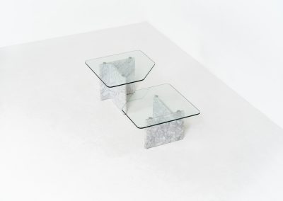Marble & glass coffee tables (Italy, 1970s). A striking pair of coffee tables that perfectly balance weight and lightness. Each piece features a sculptural marble base with elegant veining, contrasted by a floating glass top that enhances the clean, architectural lines. The asymmetrical forms give the set a playful yet refined presence, making them ideal as a duo or used separately. Both tables are in very good condition.