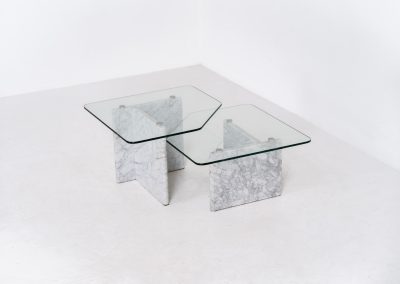 Marble & glass coffee tables (Italy, 1970s). A striking pair of coffee tables that perfectly balance weight and lightness. Each piece features a sculptural marble base with elegant veining, contrasted by a floating glass top that enhances the clean, architectural lines. The asymmetrical forms give the set a playful yet refined presence, making them ideal as a duo or used separately. Both tables are in very good condition.