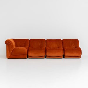 Modular sofa by Doimo Salotti (Italy, 1970s). Striking and bold modular seating system consisting of three identical elements and one corner piece, upholstered in their original vivid orange velvet. Can be arranged as a sofa or used as individual lounge chairs. Low, sculptural design with generous padding, offering both strong visual impact and excellent comfort. Professionally deep-cleaned and in very good original condition, with minor age-related wear. Some cracks to the underside dust covers (purely cosmetic, no impact on use or structure). Marked by maker.