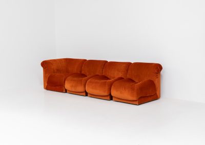 Modular sofa by Doimo Salotti (Italy, 1970s). Striking and bold modular seating system consisting of three identical elements and one corner piece, upholstered in their original vivid orange velvet. Can be arranged as a sofa or used as individual lounge chairs. Low, sculptural design with generous padding, offering both strong visual impact and excellent comfort. Professionally deep-cleaned and in very good original condition, with minor age-related wear. Some cracks to the underside dust covers (purely cosmetic, no impact on use or structure). Marked by maker.