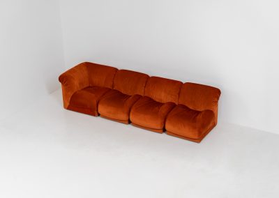 Modular sofa by Doimo Salotti (Italy, 1970s). Striking and bold modular seating system consisting of three identical elements and one corner piece, upholstered in their original vivid orange velvet. Can be arranged as a sofa or used as individual lounge chairs. Low, sculptural design with generous padding, offering both strong visual impact and excellent comfort. Professionally deep-cleaned and in very good original condition, with minor age-related wear. Some cracks to the underside dust covers (purely cosmetic, no impact on use or structure). Marked by maker.