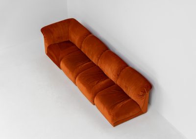 Modular sofa by Doimo Salotti (Italy, 1970s). Striking and bold modular seating system consisting of three identical elements and one corner piece, upholstered in their original vivid orange velvet. Can be arranged as a sofa or used as individual lounge chairs. Low, sculptural design with generous padding, offering both strong visual impact and excellent comfort. Professionally deep-cleaned and in very good original condition, with minor age-related wear. Some cracks to the underside dust covers (purely cosmetic, no impact on use or structure). Marked by maker.