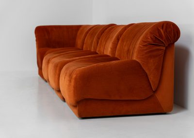 Modular sofa by Doimo Salotti (Italy, 1970s). Striking and bold modular seating system consisting of three identical elements and one corner piece, upholstered in their original vivid orange velvet. Can be arranged as a sofa or used as individual lounge chairs. Low, sculptural design with generous padding, offering both strong visual impact and excellent comfort. Professionally deep-cleaned and in very good original condition, with minor age-related wear. Some cracks to the underside dust covers (purely cosmetic, no impact on use or structure). Marked by maker.