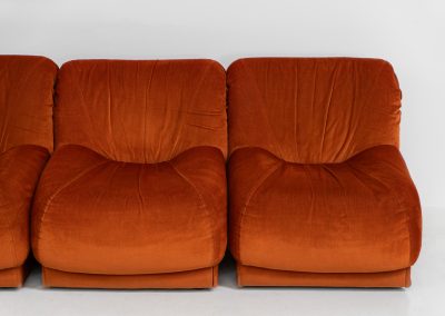 Modular sofa by Doimo Salotti (Italy, 1970s). Striking and bold modular seating system consisting of three identical elements and one corner piece, upholstered in their original vivid orange velvet. Can be arranged as a sofa or used as individual lounge chairs. Low, sculptural design with generous padding, offering both strong visual impact and excellent comfort. Professionally deep-cleaned and in very good original condition, with minor age-related wear. Some cracks to the underside dust covers (purely cosmetic, no impact on use or structure). Marked by maker.