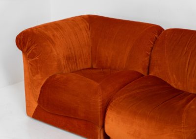 Modular sofa by Doimo Salotti (Italy, 1970s). Striking and bold modular seating system consisting of three identical elements and one corner piece, upholstered in their original vivid orange velvet. Can be arranged as a sofa or used as individual lounge chairs. Low, sculptural design with generous padding, offering both strong visual impact and excellent comfort. Professionally deep-cleaned and in very good original condition, with minor age-related wear. Some cracks to the underside dust covers (purely cosmetic, no impact on use or structure). Marked by maker.