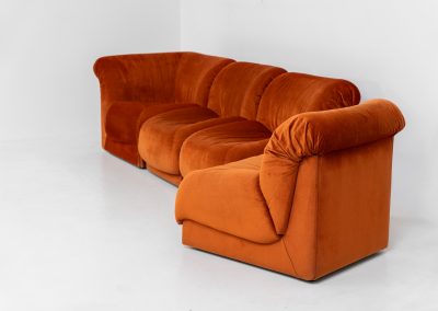 Modular sofa by Doimo Salotti (Italy, 1970s). Striking and bold modular seating system consisting of three identical elements and one corner piece, upholstered in their original vivid orange velvet. Can be arranged as a sofa or used as individual lounge chairs. Low, sculptural design with generous padding, offering both strong visual impact and excellent comfort. Professionally deep-cleaned and in very good original condition, with minor age-related wear. Some cracks to the underside dust covers (purely cosmetic, no impact on use or structure). Marked by maker.
