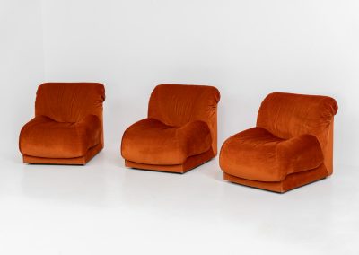 Modular sofa by Doimo Salotti (Italy, 1970s). Striking and bold modular seating system consisting of three identical elements and one corner piece, upholstered in their original vivid orange velvet. Can be arranged as a sofa or used as individual lounge chairs. Low, sculptural design with generous padding, offering both strong visual impact and excellent comfort. Professionally deep-cleaned and in very good original condition, with minor age-related wear. Some cracks to the underside dust covers (purely cosmetic, no impact on use or structure). Marked by maker.
