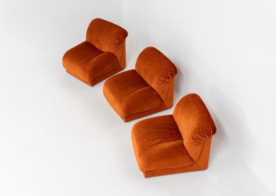 Modular sofa by Doimo Salotti (Italy, 1970s). Striking and bold modular seating system consisting of three identical elements and one corner piece, upholstered in their original vivid orange velvet. Can be arranged as a sofa or used as individual lounge chairs. Low, sculptural design with generous padding, offering both strong visual impact and excellent comfort. Professionally deep-cleaned and in very good original condition, with minor age-related wear. Some cracks to the underside dust covers (purely cosmetic, no impact on use or structure). Marked by maker.