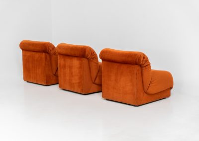 Modular sofa by Doimo Salotti (Italy, 1970s). Striking and bold modular seating system consisting of three identical elements and one corner piece, upholstered in their original vivid orange velvet. Can be arranged as a sofa or used as individual lounge chairs. Low, sculptural design with generous padding, offering both strong visual impact and excellent comfort. Professionally deep-cleaned and in very good original condition, with minor age-related wear. Some cracks to the underside dust covers (purely cosmetic, no impact on use or structure). Marked by maker.