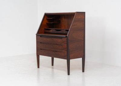 “No. 63” secretary by Kai Kristiansen for Torring Møbelfabrik (Denmark, 1960s). This very hard to find piece is one of our favorite secretaries and an example of high quality Danish craftsmanship. It features stunning aesthetics and nifty details like the sculptural handles or the convenient pivoting drop-down leaf. This particular piece is crafted out of rosewood and has an extraordinary woodgrain! It is in splendid condition with a minor repair mark on the lowest drawer.