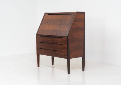 “No. 63” secretary by Kai Kristiansen for Torring Møbelfabrik (Denmark, 1960s). This very hard to find piece is one of our favorite secretaries and an example of high quality Danish craftsmanship. It features stunning aesthetics and nifty details like the sculptural handles or the convenient pivoting drop-down leaf. This particular piece is crafted out of rosewood and has an extraordinary woodgrain! It is in splendid condition with a minor repair mark on the lowest drawer.