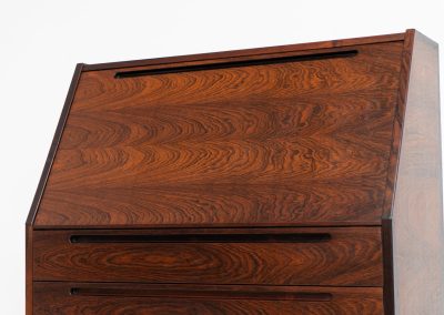 “No. 63” secretary by Kai Kristiansen for Torring Møbelfabrik (Denmark, 1960s). This very hard to find piece is one of our favorite secretaries and an example of high quality Danish craftsmanship. It features stunning aesthetics and nifty details like the sculptural handles or the convenient pivoting drop-down leaf. This particular piece is crafted out of rosewood and has an extraordinary woodgrain! It is in splendid condition with a minor repair mark on the lowest drawer.